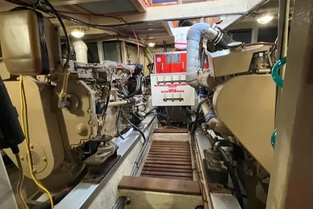 Slide: The Image of Engine room of 1987 Grand Banks 42 Classic Trawler, showcasing dual engines and control systems. - 49