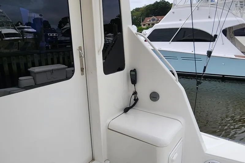 Slide: The Image of 2001 Ocean Yachts 56 Super Sport boat docked, featuring a white exterior and fishing equipment. - 21