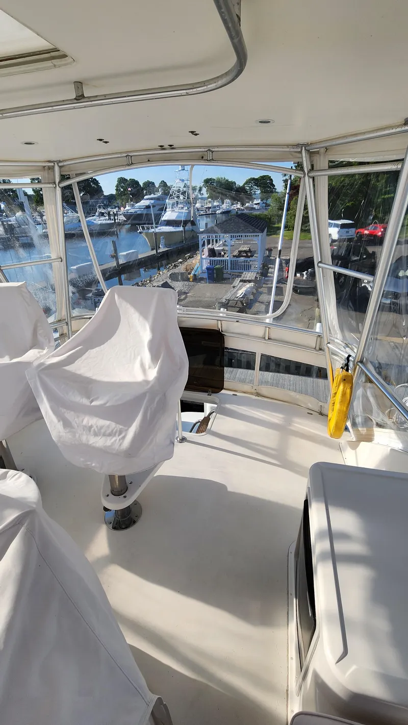 Slide: The Image of 2001 Ocean Yachts 56 Super Sport yacht interior with covered seating and marina view. - 26