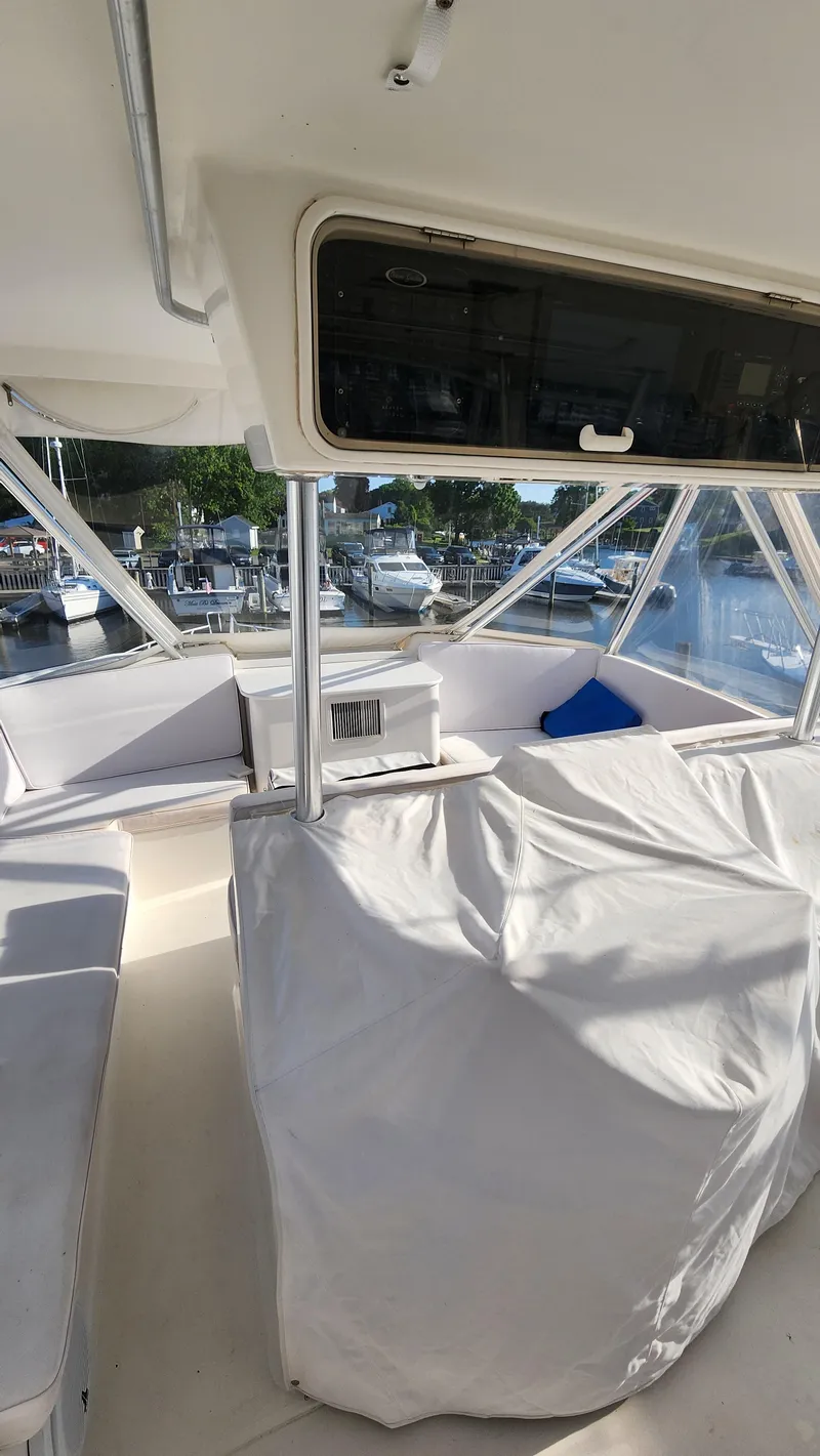 Slide: The Image of Interior view of a 2001 Ocean Yachts 56 Super Sport boat, featuring covered seating. - 27