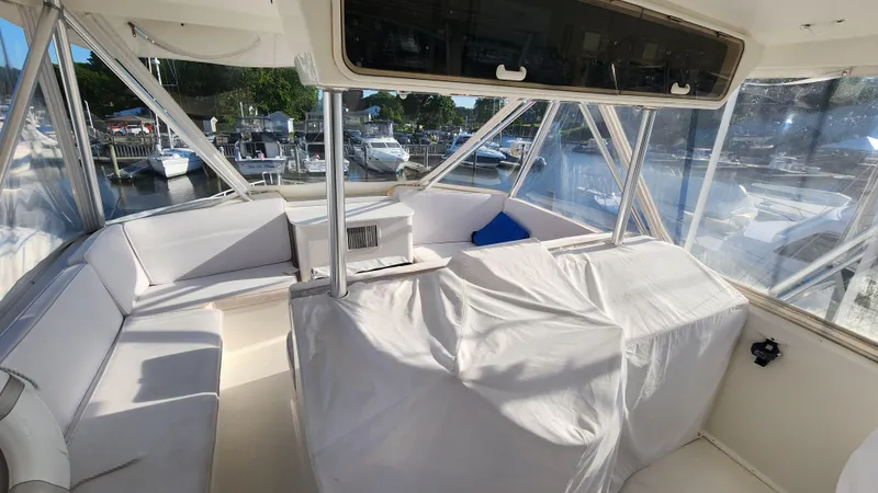 Slide: The Image of 2001 Ocean Yachts 56 Super Sport yacht interior with white seating and marina view. - 28