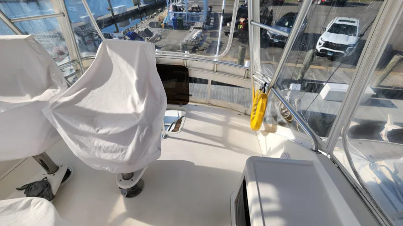 Slide: The Image of 2001 Ocean Yachts 56 Super Sport yacht interior with covered seats and marina view. - 29