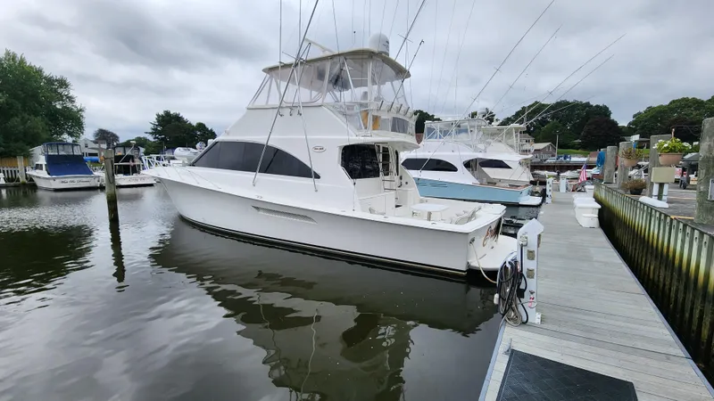 Slide: The Image of 2001 Ocean Yachts 56 Super Sport docked at a marina under cloudy skies. - 8