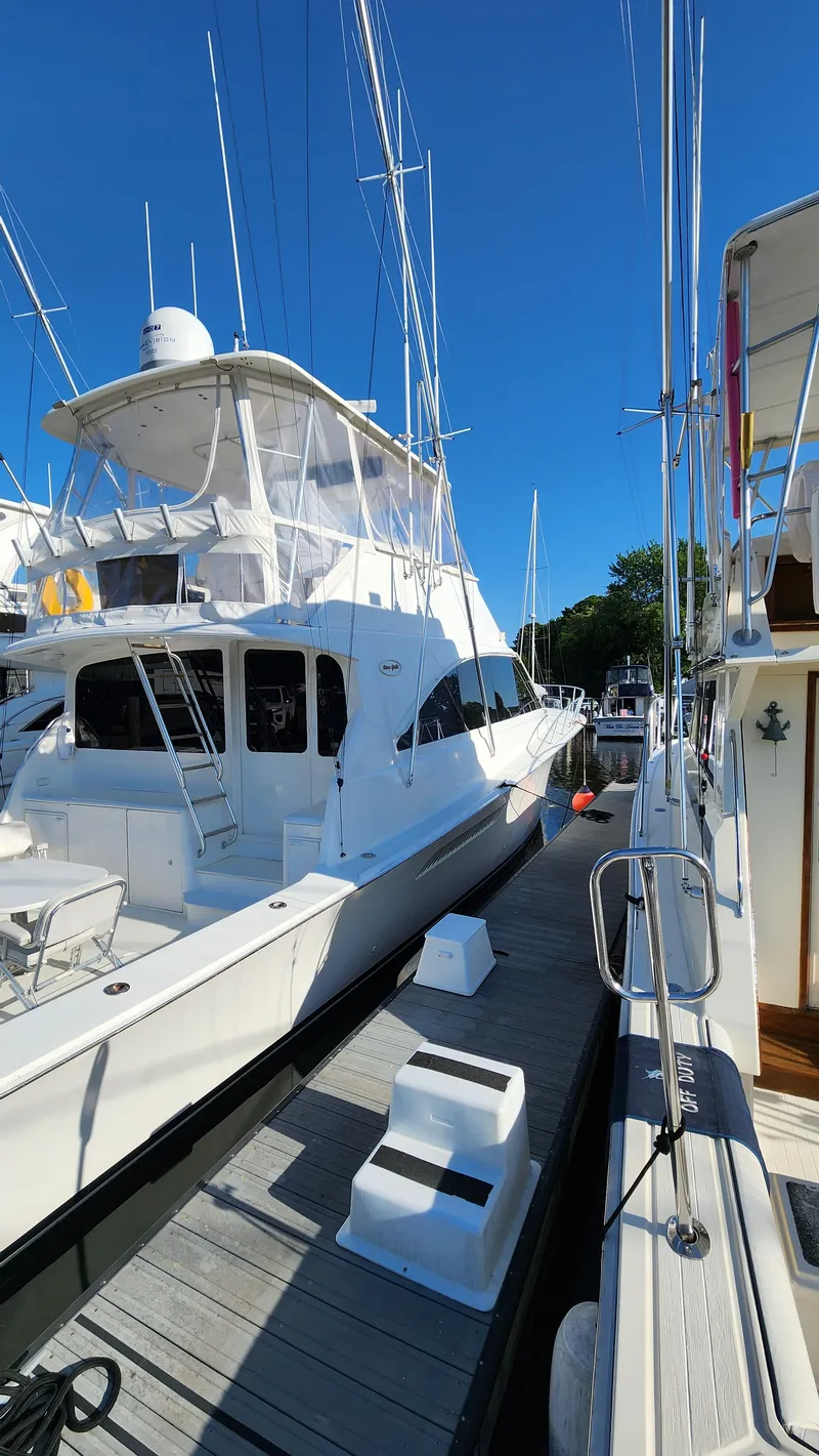 Slide: The Image of 2001 Ocean Yachts 56 Super Sport docked at a marina under clear blue skies. - 1