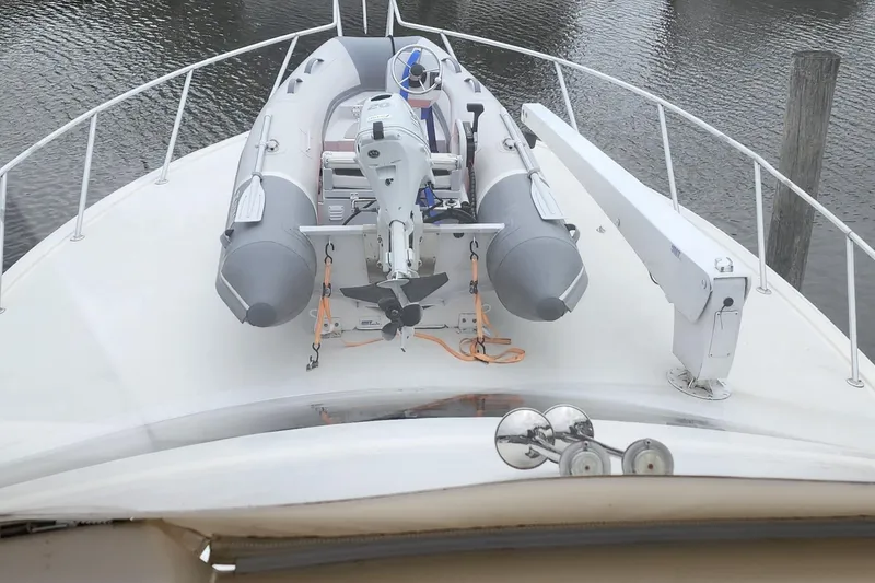 Slide: The Image of 2001 Ocean Yachts 56 Super Sport with inflatable boat on deck, docked on calm water. - 17