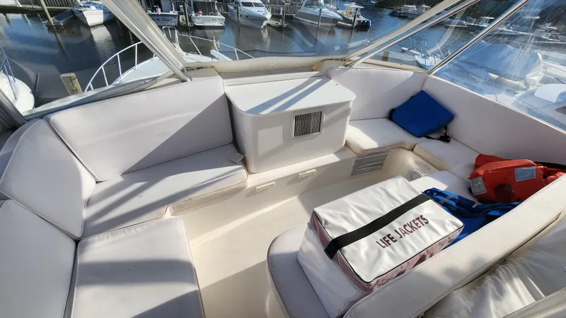 Slide: The Image of 2001 Ocean Yachts 56 Super Sport interior with seating and life jackets, docked at marina. - 24