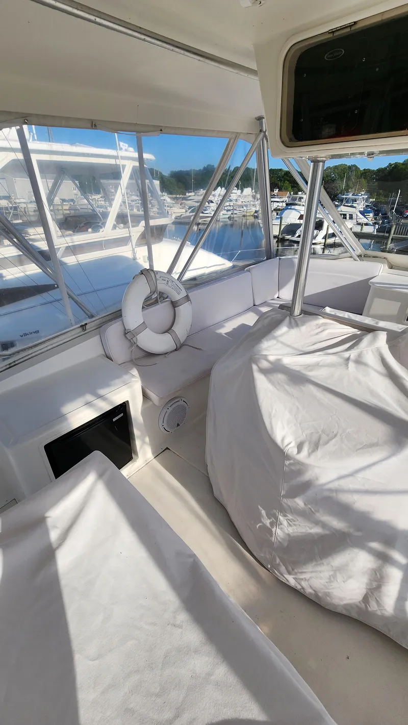 Slide: The Image of 2001 Ocean Yachts 56 Super Sport interior with covered seating and marina view. - 25