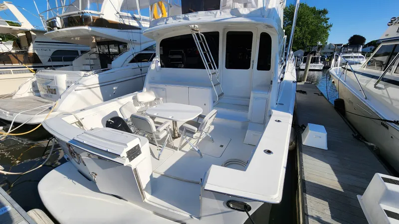 Slide: The Image of 2001 Ocean Yachts 56 Super Sport docked, featuring spacious deck and seating area. - 6