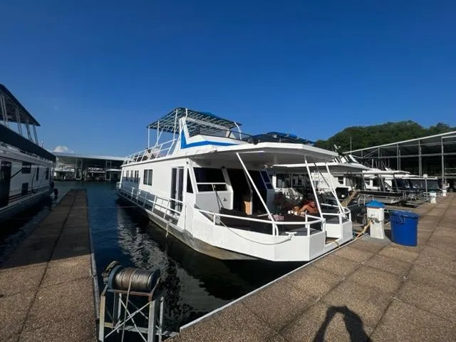 The Image of 1988 Stardust Cruisers houseboat docked at a marina under a clear blue sky. - 0
