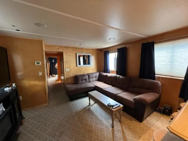 Slide: The Image of 1988 Stardust Cruisers houseboat interior with cozy living area and large sectional sofa. - 2