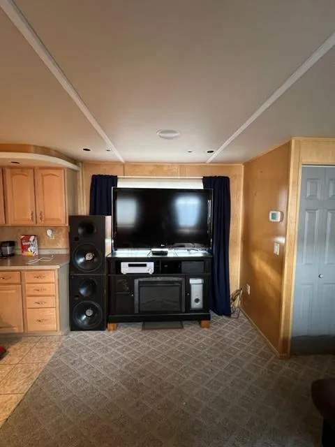 Slide: The Image of Interior of a 1988 Stardust Cruisers houseboat with entertainment center and kitchen area. - 5