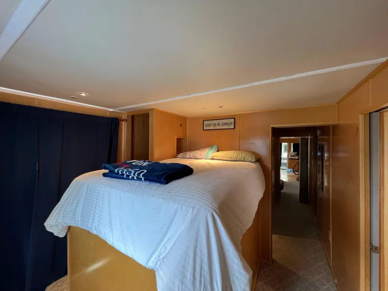 Slide: The Image of 1988 Stardust Cruisers houseboat interior bedroom with elevated bed and cozy decor. - 7