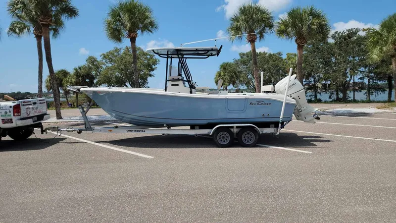 Slide: The Image of 2017 Sea Chaser 24 HFC boat on a trailer in a parking lot with palm trees. - 27