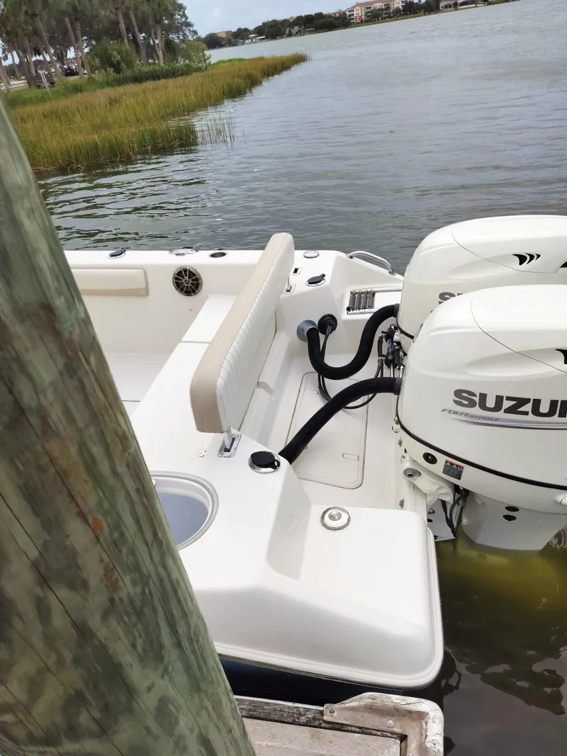 Slide: The Image of 2017 Sea Chaser 24 HFC boat with Suzuki engines docked by a lake. - 7