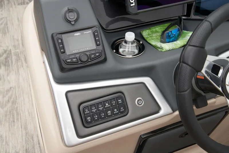 Slide: The Image of 2024 Ranger Reata 220FC boat dashboard with control panel, radio, and cup holder. - 33