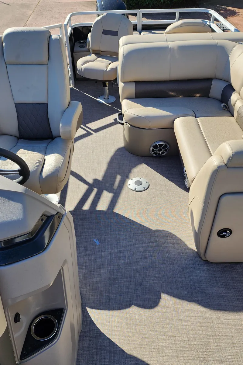 Slide: The Image of 2024 Sun Tracker SportFish 22 DLX pontoon boat interior with beige seating. - 3
