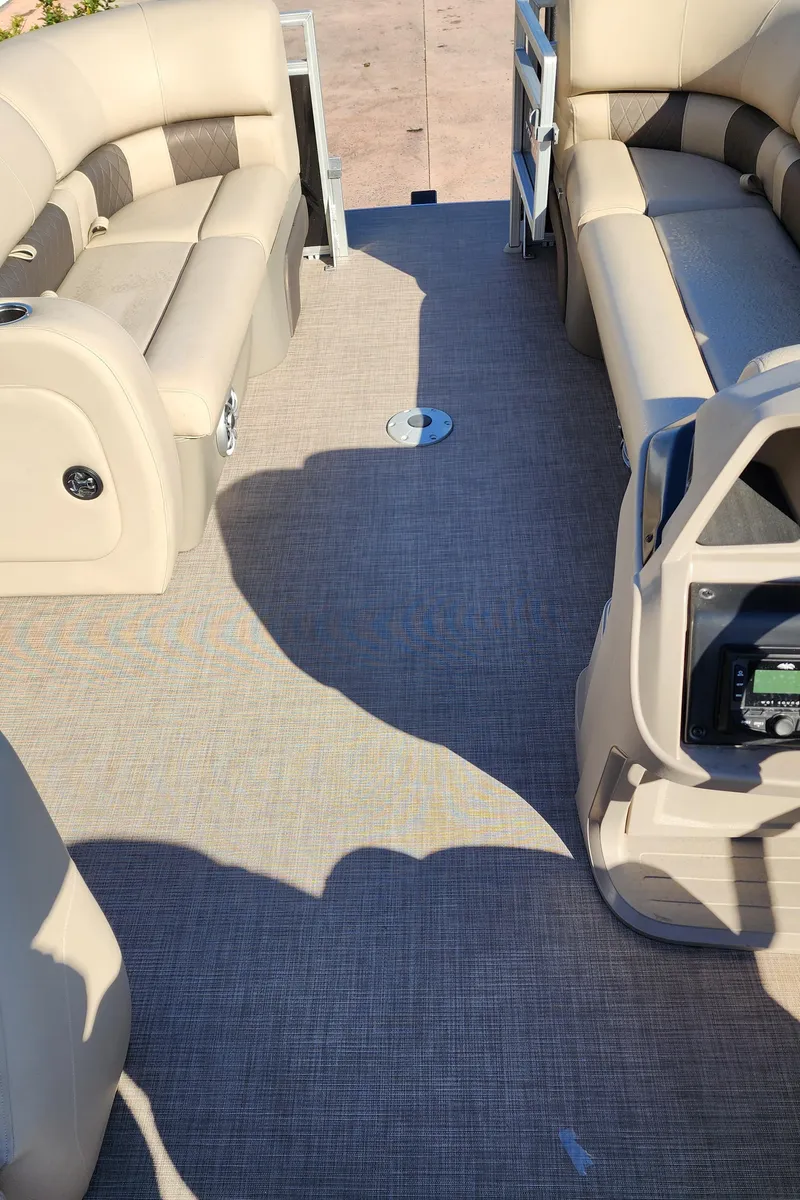 Slide: The Image of 2024 Sun Tracker SportFish 22 DLX pontoon boat interior with beige seating and carpet. - 5