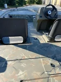 Slide: The Image of 2024 Tracker Grizzly 1754 SC boat interior with camouflage design and steering console. - 4