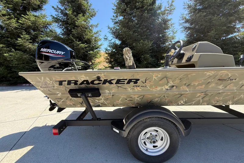 Slide: The Image of 2024 Tracker Grizzly 1754 SC boat with Mercury engine on trailer, outdoors. - 4