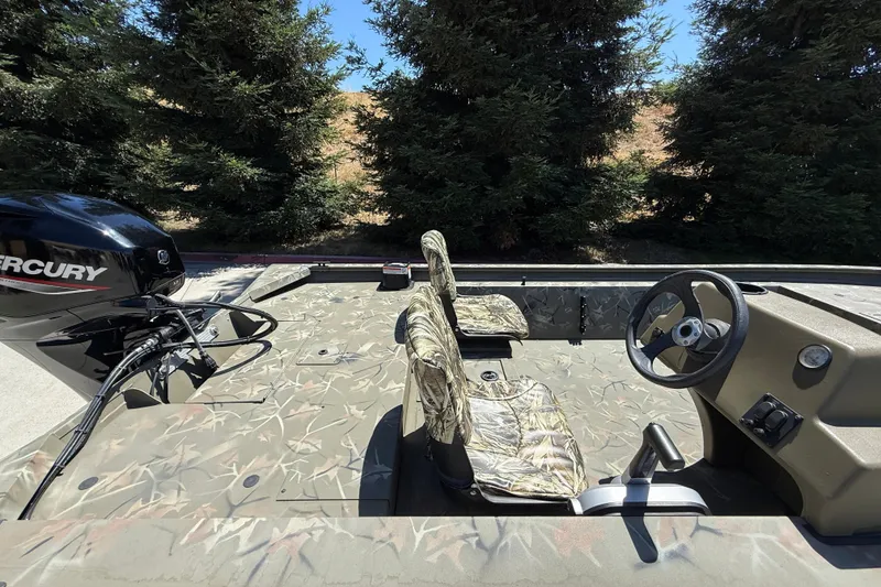 Slide: The Image of 2024 Tracker Grizzly 1754 SC boat with camo seats and Mercury outboard motor. - 10