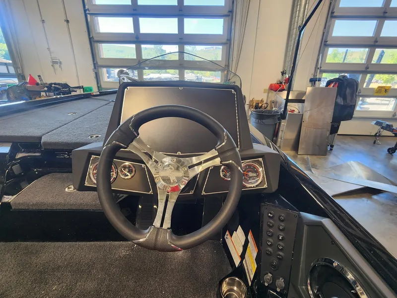 Slide: The Image of 2024 Ranger Z518 boat dashboard with steering wheel and control panel in a garage. - 4