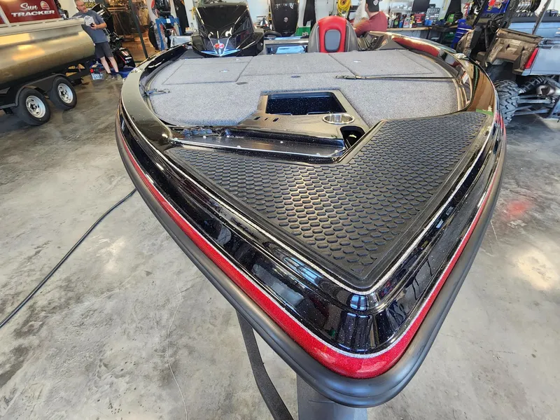 Slide: The Image of 2024 Ranger Z518 boat in showroom, front deck view with carpet and storage compartments. - 5
