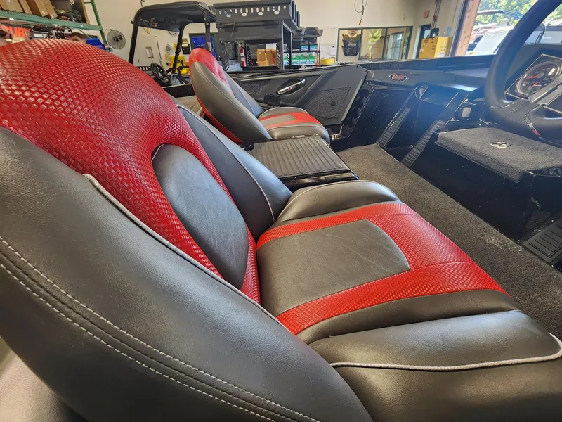 Slide: The Image of 2024 Ranger Z518 boat interior with red and black seats in a workshop. - 6