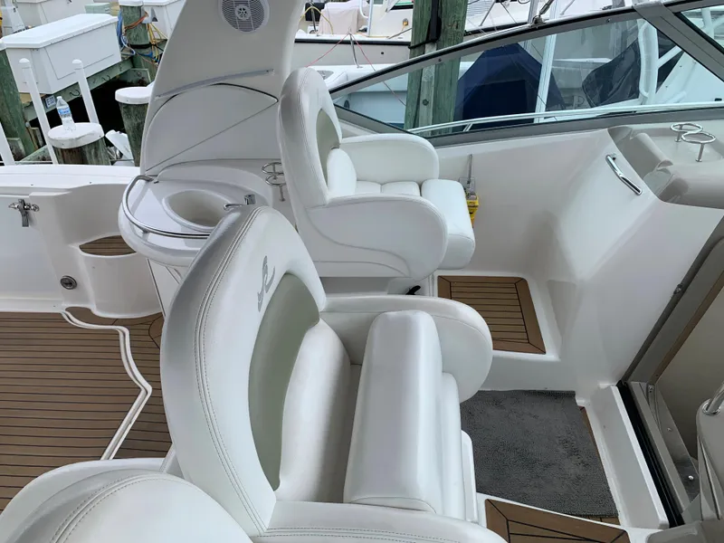 Slide: The Image of 2006 Sea Ray 340 Sundancer cockpit with white leather seats and teak flooring. - 19