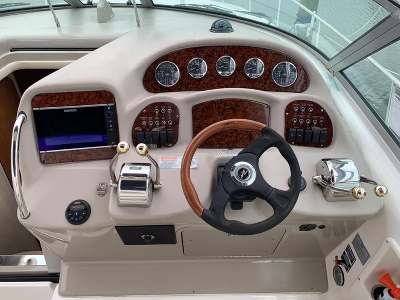 Slide: The Image of 2006 Sea Ray 340 Sundancer helm with wood accents and modern controls. - 22