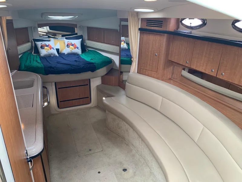 Slide: The Image of Interior of 2006 Sea Ray 340 Sundancer with bed, seating, and wooden cabinetry. - 28