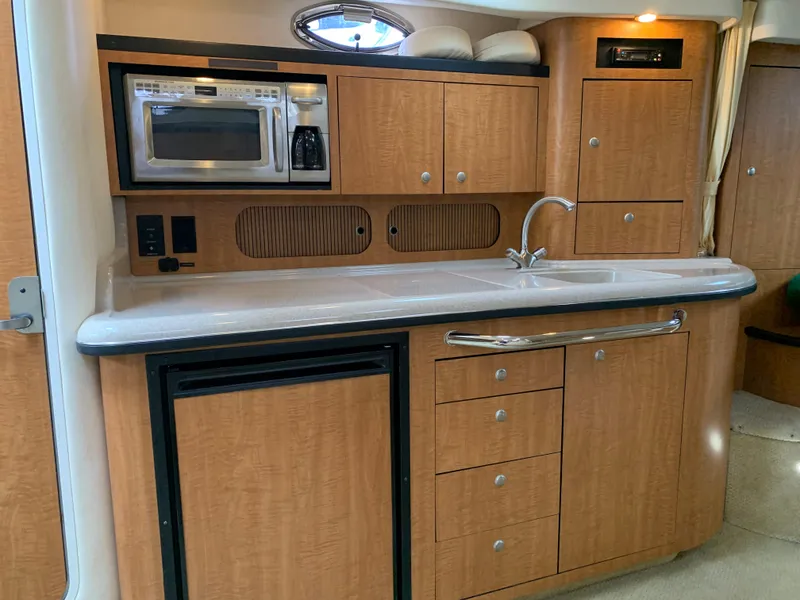 Slide: The Image of 2006 Sea Ray 340 Sundancer galley with microwave, sink, and storage cabinets. - 30