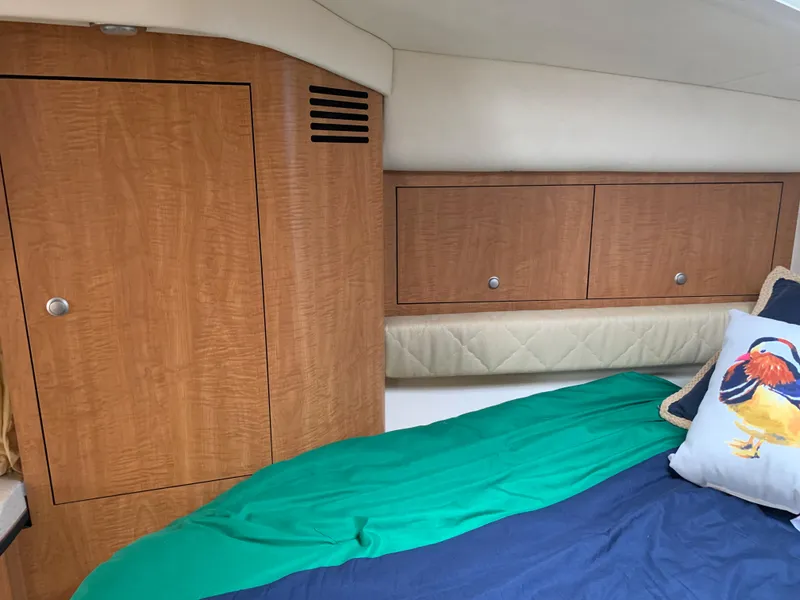 Slide: The Image of Interior cabin of 2006 Sea Ray 340 Sundancer with wooden cabinets and colorful bedding. - 34