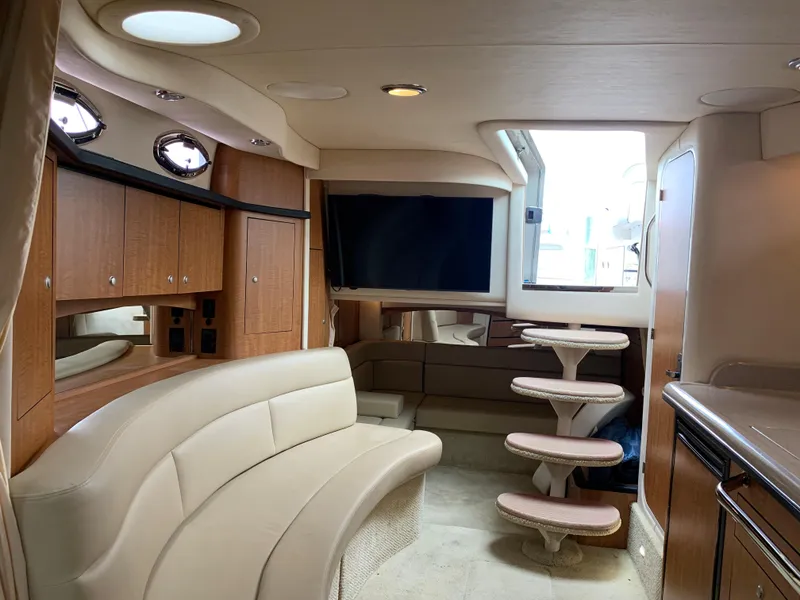 Slide: The Image of 2006 Sea Ray 340 Sundancer yacht interior with beige seating and wooden cabinetry. - 36