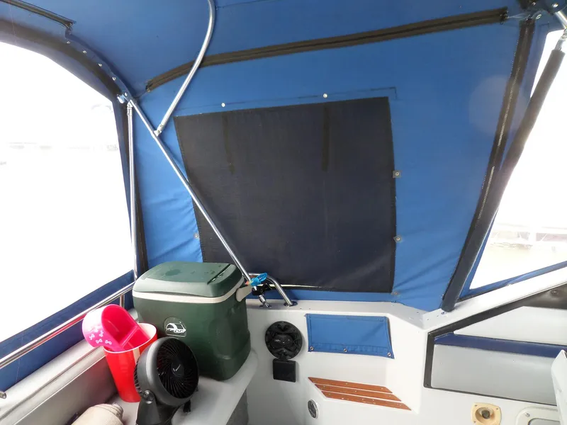 Slide: The Image of Interior of a 1986 Wellcraft Monte Carlo 2800 boat with blue canopy. - 12