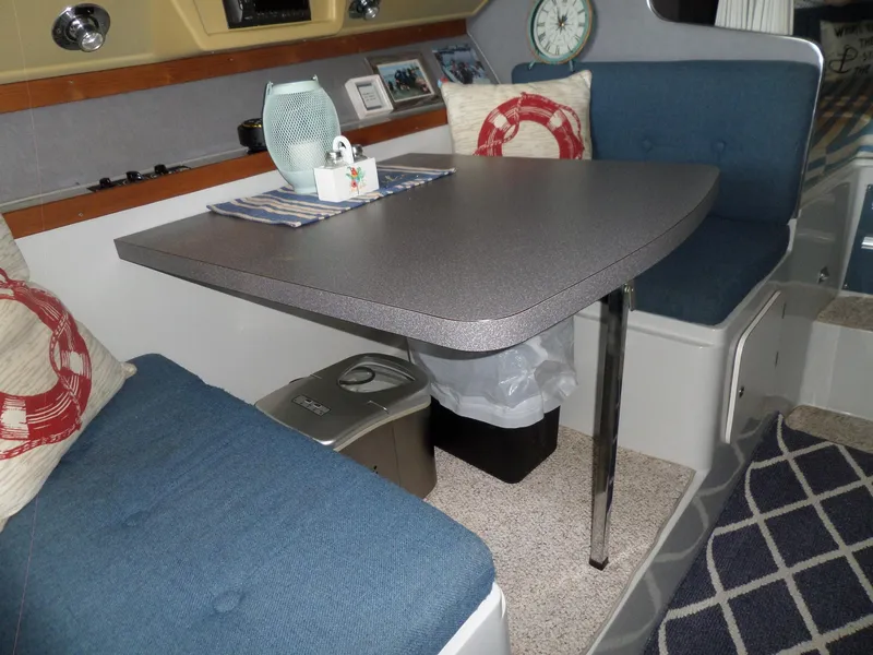 Slide: The Image of Interior of 1986 Wellcraft Monte Carlo 2800 with dining table and blue cushioned seating. - 31