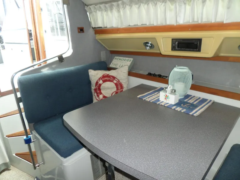 Slide: The Image of 1986 Wellcraft Monte Carlo 2800 interior dining area with blue seating and table. - 32