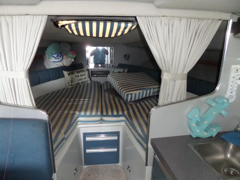 Slide: The Image of 1986 Wellcraft Monte Carlo 2800 cabin interior with striped bedding and nautical decor. - 36