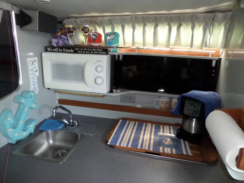 Slide: The Image of 1986 Wellcraft Monte Carlo 2800 kitchen area with microwave, sink, and coffee maker. - 39