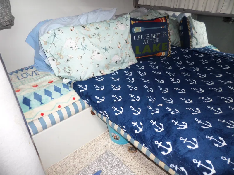 Slide: The Image of Cozy cabin bed in 1986 Wellcraft Monte Carlo 2800 with nautical-themed bedding. - 44