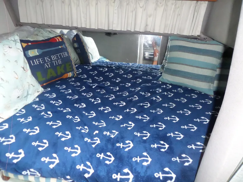 Slide: The Image of Cozy cabin bed in 1986 Wellcraft Monte Carlo 2800 with nautical-themed bedding. - 45