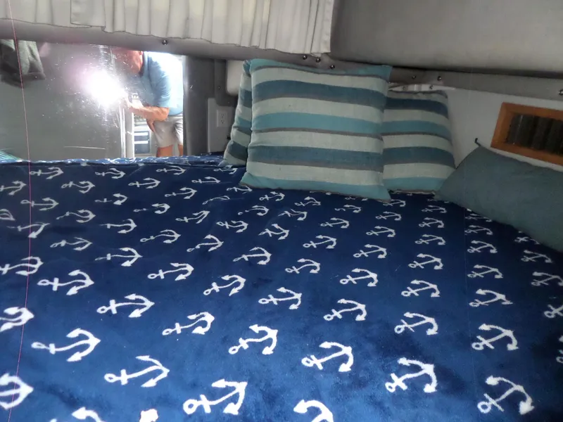 Slide: The Image of 1986 Wellcraft Monte Carlo 2800 cabin with anchor-themed bedding and striped pillows. - 46