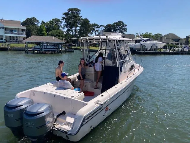 Slide: The Image of 2005 Grady-White Sailfish 282 boat with people onboard, docked in a scenic marina. - 16