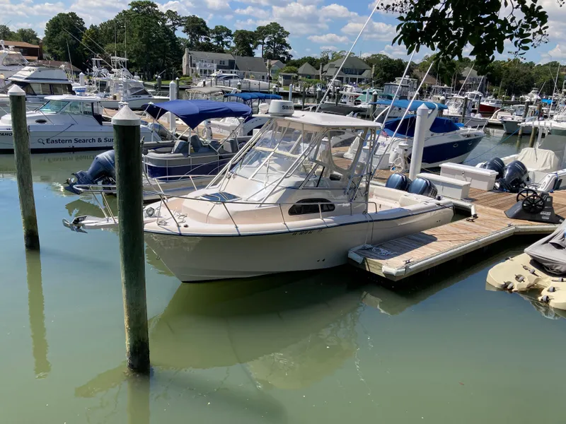 Slide: The Image of 2005 Grady-White Sailfish 282 docked in a marina, surrounded by other boats. - 5