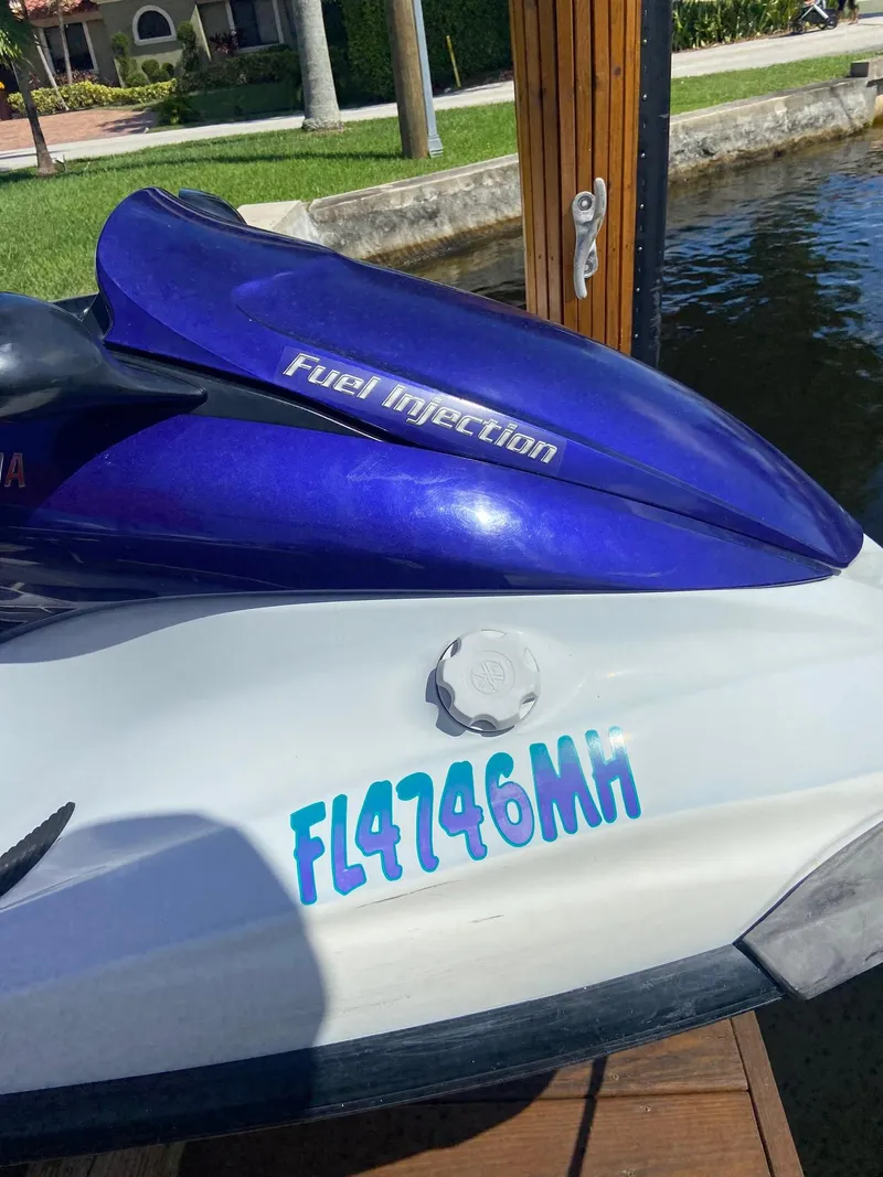 Slide: The Image of 2003 Yamaha WaveRunner FX 140 jet ski docked, showing registration number FL4746MH. - 2