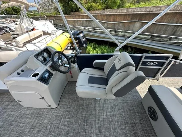 Slide: The Image of 2023 Harris 210 Cruiser boat interior with captain's chair and control console. - 13