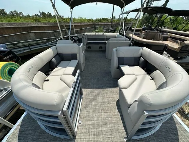 Slide: The Image of 2023 Harris 210 Cruiser pontoon boat with spacious seating and modern design. - 6