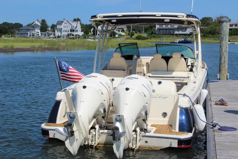 Slide: The Image of 2017 Chris-Craft Calypso 30 boat docked with dual engines and American flag. - 1