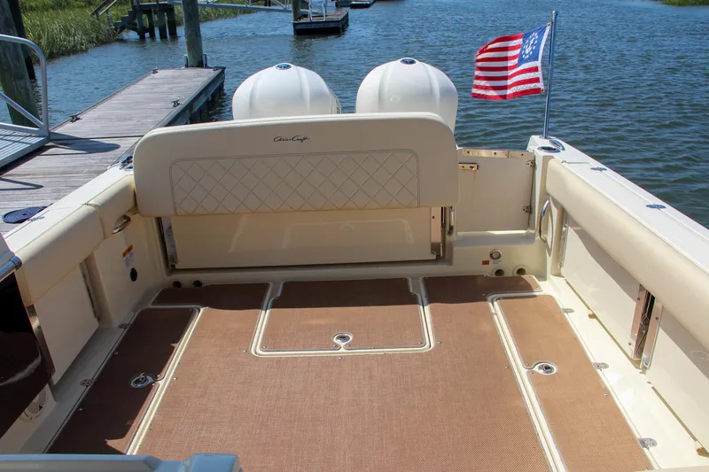 Slide: The Image of 2017 Chris-Craft Calypso 30 boat deck with American flag, docked by the water. - 11