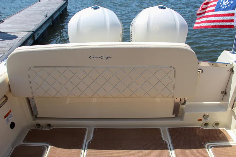 Slide: The Image of 2017 Chris-Craft Calypso 30 boat with twin engines and American flag at dock. - 12