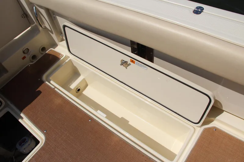 Slide: The Image of 2017 Chris-Craft Calypso 30 boat storage compartment with beige interior. - 16